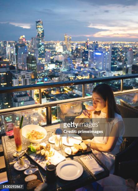 adulto bello asiatico che utilizza la cattura dello smartphone mobile celebrazione della cena di lusso - woman capturing city night foto e immagini stock