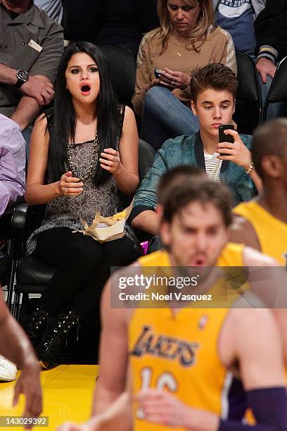 Selena Gomez and Justin Bieber attend a basketball game between the San Antonio Spurs and the Los Angeles Lakers at Staples Center on April 17, 2012...