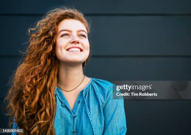 woman looking up and smiling - alleen één jonge vrouw stockfoto's en -beelden