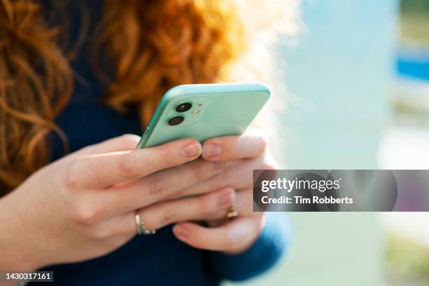 close up or woman using smart phone - holding mobile phone stock-fotos und bilder