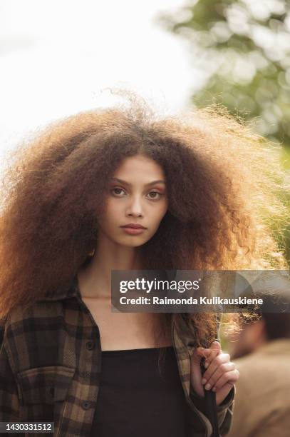 Model wearing a black top and brown checkered shirt outside the Hermes show during Paris Fashion Week - Womenswear Spring/Summer 2023 on October 01,...