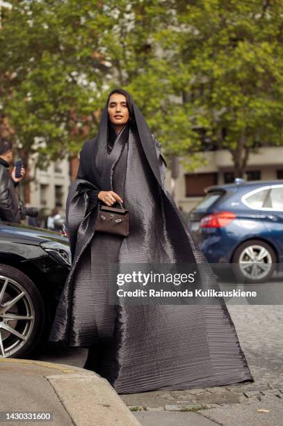 Guest wearing a grey ruffled gown and brown Hermes bag outside the Hermes show during Paris Fashion Week - Womenswear Spring/Summer 2023 on October...