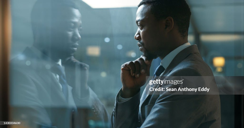Réflexion, idée et état d’esprit avec un homme d’affaires debout dans son bureau la nuit tout en se concentrant sur l’avenir de son entreprise. Mission, vision et développement avec un employé masculin au travail près d’une fenêtre