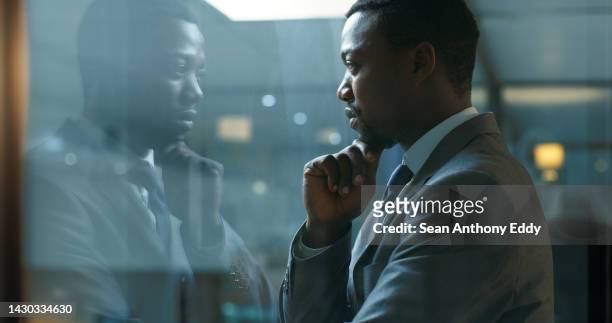 thinking, idea and mindset with a business man standing in his office at night while focused on the future of his company. mission, vision and development with a male employee at work by a window - reflection stock pictures, royalty-free photos & images