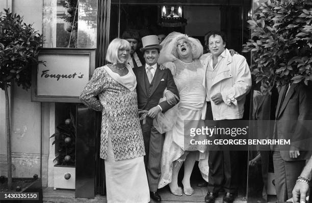 French producers Eddie Barclay and Paul Lederman attend the joke wedding of French humorists Thierry le Luron and Coluche, wearing the bride's dress,...