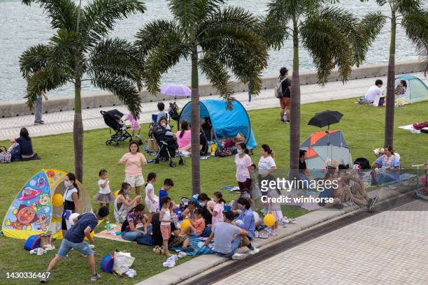 west kowloon waterfront promenade in hong kong - hong kong family stockfoto's en -beelden
