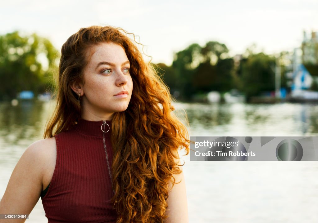 Woman looking away next to water