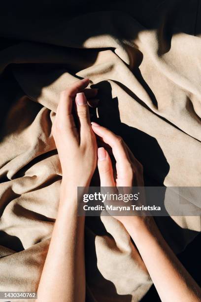 beautiful female hands with gentle manicure on a fabric background. women's nails. - manicura fotografías e imágenes de stock