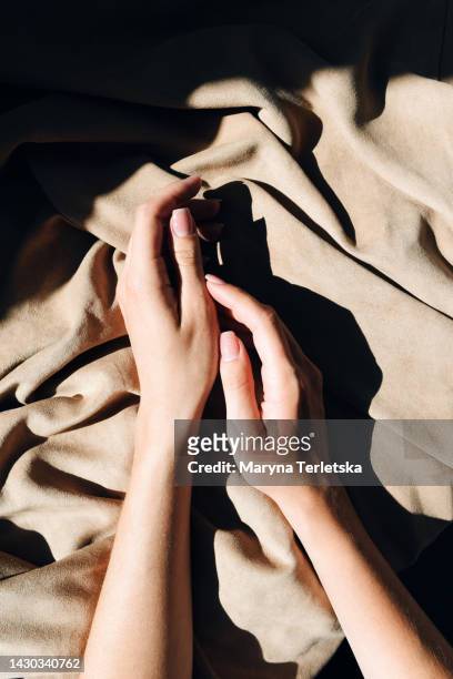 beautiful female hands with gentle manicure on a fabric background. women's nails. - fingernail foto e immagini stock