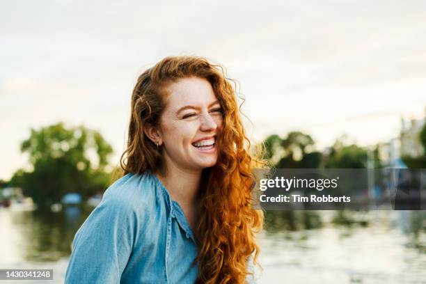 happy woman laughing next to water - natural beauty people stock pictures, royalty-free photos & images