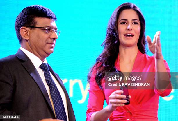 Bollywood film actress Katrina Kaif displays a BlackBerry Curve 9220 as managing director of BlackBerry India, Sunil Dutt looks on during the product...