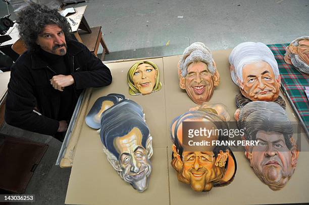 Michel Foucault drawner and sculptor at the Cesar mask maker company poses in front of 2012 French presidential election candidates masks he created,...