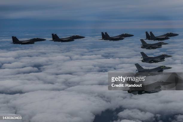 In this handout image released by the South Korean Defense Ministry, South Korean Air Force F-15Ks and U.S. Air Force F-16 fighter jets fly over the...