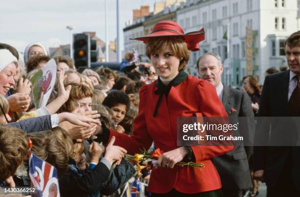 Princess Diana, wearing a red-and-black Donald Campbell suit and a John Boyd hat, greets well wishers during a visit to Rhyl, Denbighshire, Wales,...
