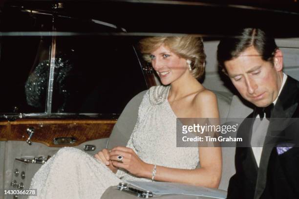 Princess Diana, wearing a white Hachi one-shoulder evening gown, in her car with Prince Charles following the London premiere of 'Octopussy,' held at...
