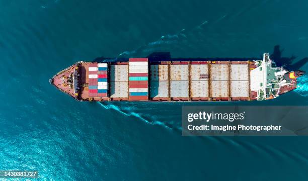 aerial top view, large red container ships loaded container are running in the estuary, business of transportation, import and export by container ship. - shipping container top view - fotografias e filmes do acervo
