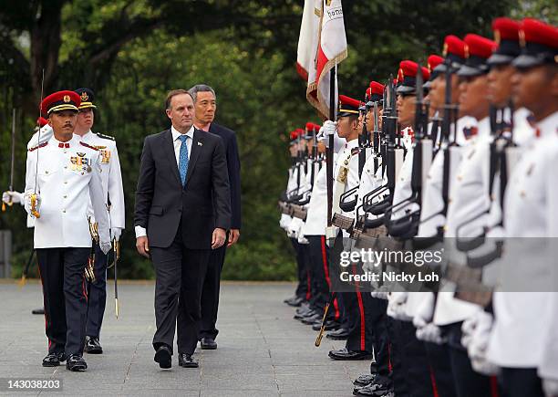 New Zealand Prime Minister John Key walks with Singapore Prime Minister Lee Hsien Loong during a honour guard welcome ceremony at the Istana on April...