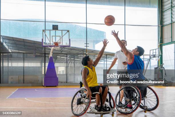 disabled sport men in action while playing indoor basketball at a basketball court - sia - fotografias e filmes do acervo