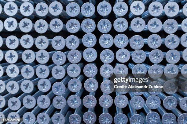 self-tapping screws for connecting parts. bolts or screws, design abstraction. industrial style. the concept of construction and repair. background of nails. - ferramenta foto e immagini stock