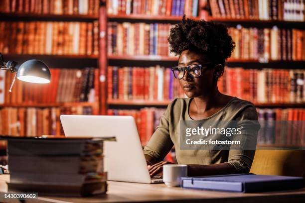 young woman studying in a library - library　woman stockfoto's en -beelden