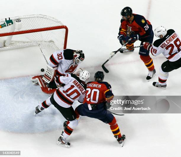 Sean Bergenheim and Mikael Samuelsson look on as the puck shot by Marcel Goc of the Florida Panthers scores past goaltender Martin Brodeur of the New...