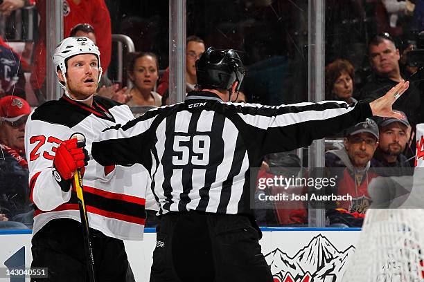 David Clarkson of the New Jersey Devils is held back by linesman Steve Barton after being checked into the boards by the Florida Panthers in Game Two...