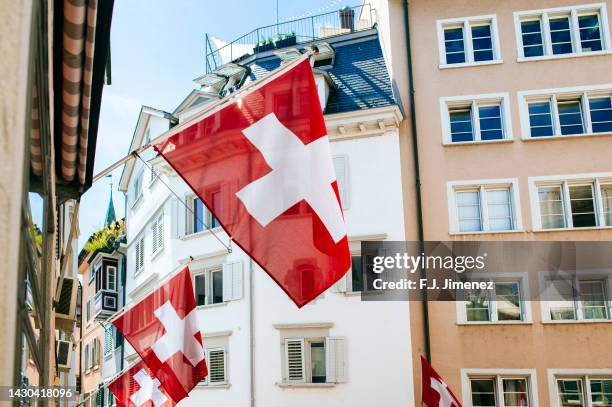 swiss flag in zurich street - schweizer flagge stock-fotos und bilder