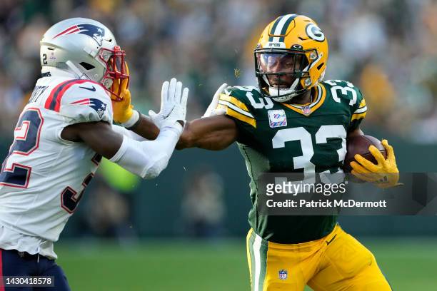 Aaron Jones of the Green Bay Packers stiff arms Devin McCourty of the New England Patriots during the third quarter at Lambeau Field on October 02,...