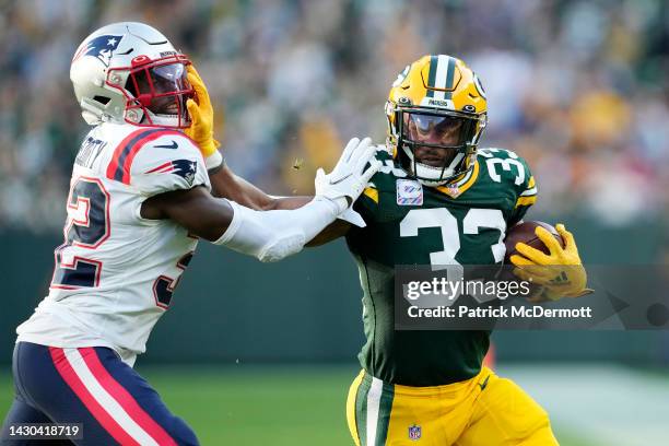 Aaron Jones of the Green Bay Packers stiff arms Devin McCourty of the New England Patriots during the third quarter at Lambeau Field on October 02,...