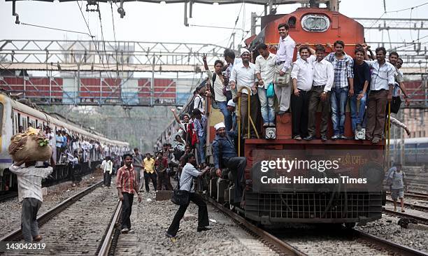 Commuters ride on the outside a local train in Vidyavihar as many people were stranded after a disruption on the on central line April 18, 2012 in...