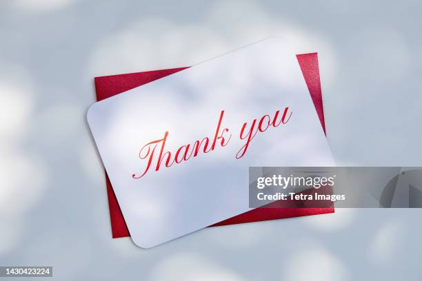 overhead view of thank you card and envelope - thank-you-englischer-satz stock-fotos und bilder
