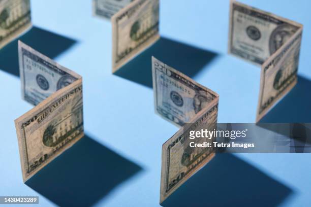 folded twenty dollar bills against blue background - banconota da 20 dollari statunitensi foto e immagini stock