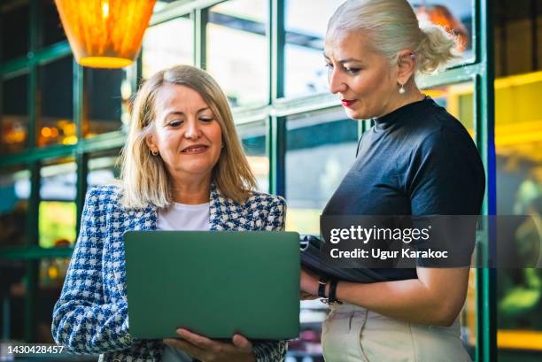coworking business women using mobile devices - turkish woman stock pictures, royalty-free photos & images