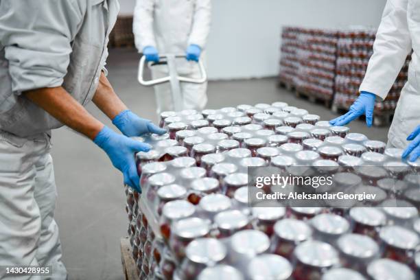 workers in food processing plant dragging crates full of stuffed pepper jars on forklift to storage room - voedsel-verwerkingsbedrijf stockfoto's en -beelden
