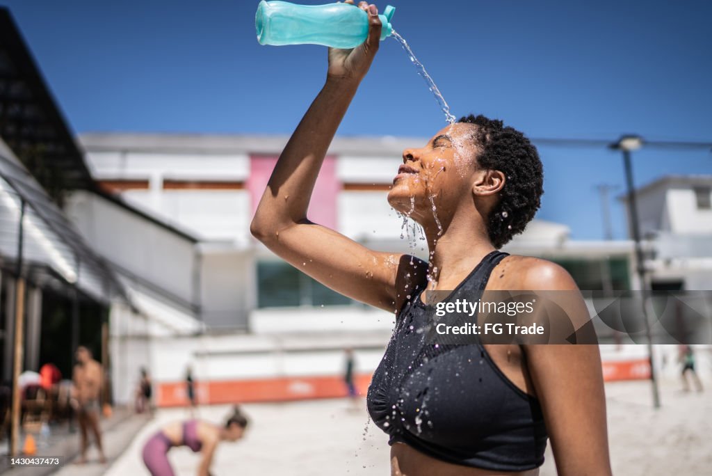Woman pouring water over her face