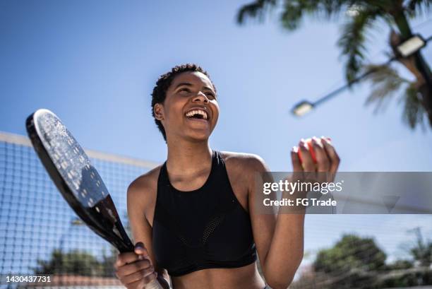 happy woman celebrating during beach tennis match - actieve levenswijze stockfoto's en -beelden