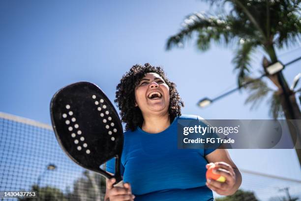 glückliche frau feiert beim beach-tennis-match - tennis court and low angle stock-fotos und bilder