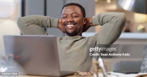 man with his laptop, taking a rest and relax after doing work in his home. black man, smiling and happy person being done with a task on his computer. stress free, relaxing and working online - hands behind head stock pictures, royalty-free photos & images