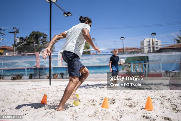 entraînement de l’homme dans un tribunal de sable - football de plage photos et images de collection