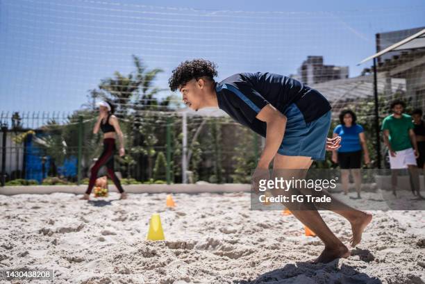 man training in a sand court - beach football stock pictures, royalty-free photos & images