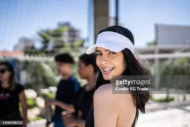 retrato de una mujer joven en una cancha de tenis de playa - braces and smiles fotografías e imágenes de stock
