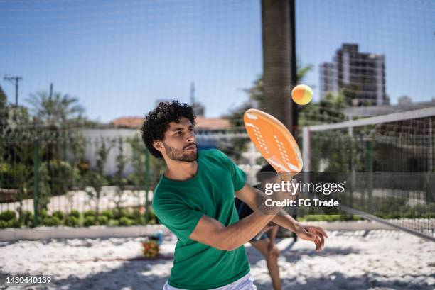 young man playing beach tennis - racketball stock pictures, royalty-free photos & images