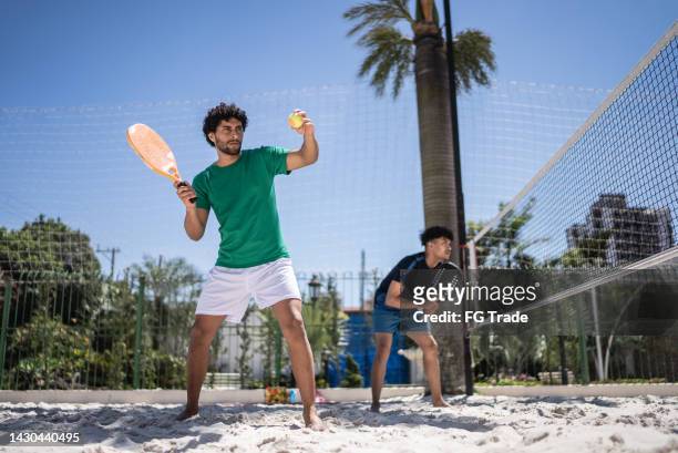 jovem que joga tênis de praia - tênis esporte de raquete - fotografias e filmes do acervo