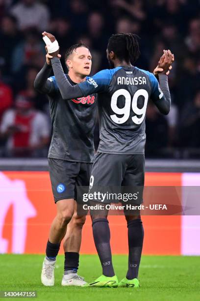 Piotr Zielinski of SSC Napoli celebrates with teammate Andre-Frank Zambo Anguissa after scoring their team's third goal during the UEFA Champions...