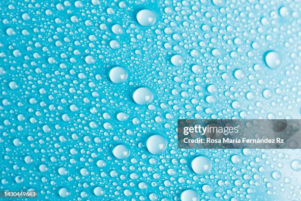 full frame of the textures formed by drops of water on a gradiant blue color background. - water fall stockfoto's en -beelden