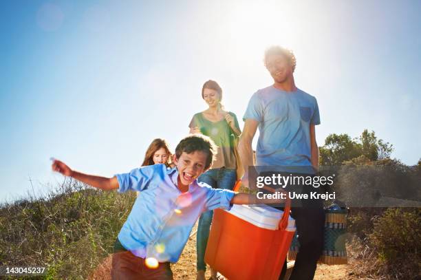 family walking with picnic paraphernalia in park - family at a picnic ストックフォトと画像