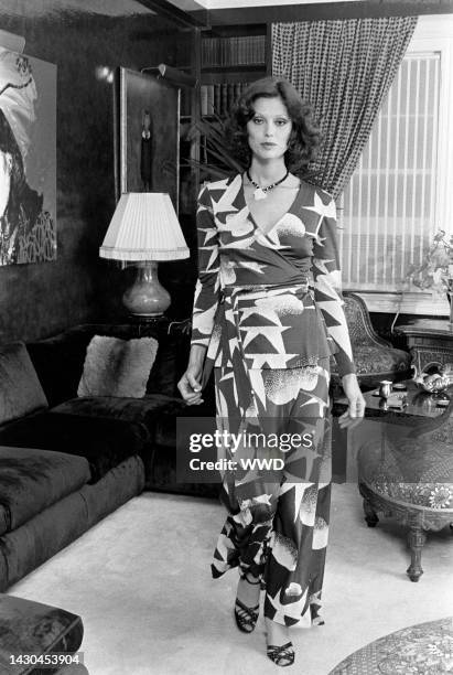 Model wears a Diane von Furstenberg seagull-printed wrap dress and poses in the designer's apartment. An Andy Warhol portrait of Diane von...