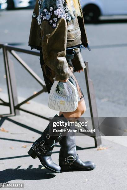 Niki Wu Jie poses wearing a Miu Miu leather jacket, Miu Miu dress, Miu Miu white leather bag and Miu Miu biker boots after the Miu Miu show at the...