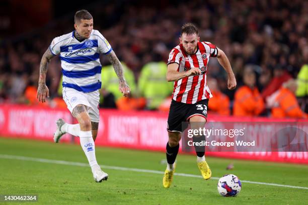 Rhys Norrington-Davies of Sheffield United runs with the ball whilst under pressure from Lyndon Dykes of Queens Park Rangers during the Sky Bet...