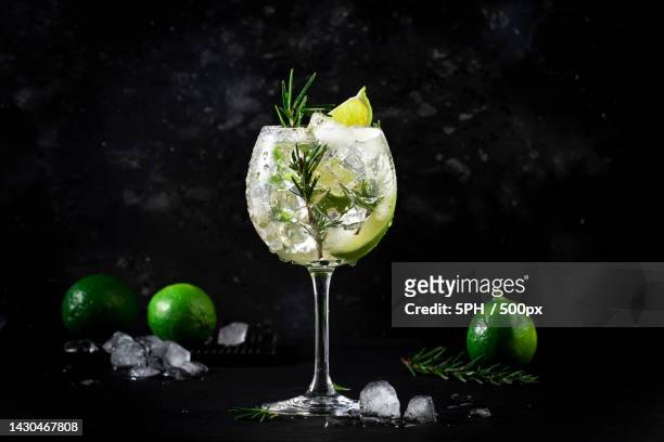 close-up of drink on table against black background - gin tonic stock-fotos und bilder